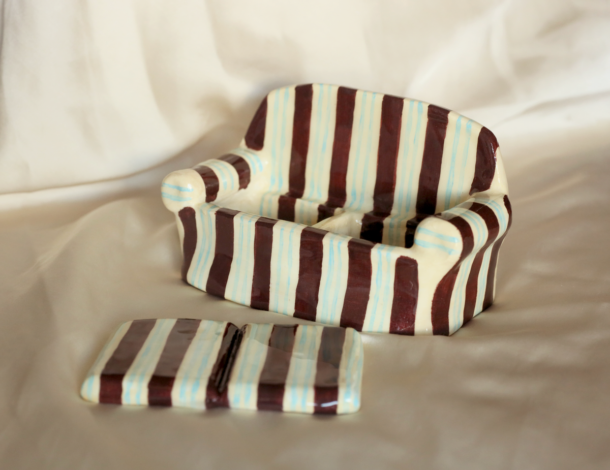 Close-up of multicolor striped clay sofa jewelry holder