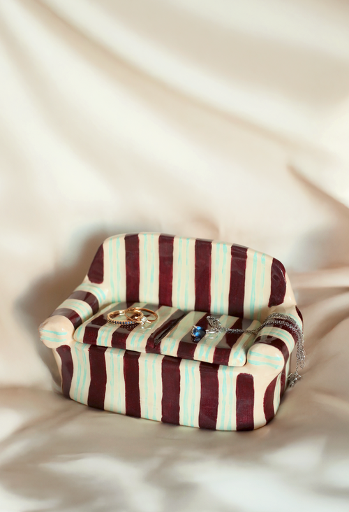Side view of multicolor striped clay sofa jewelry holder